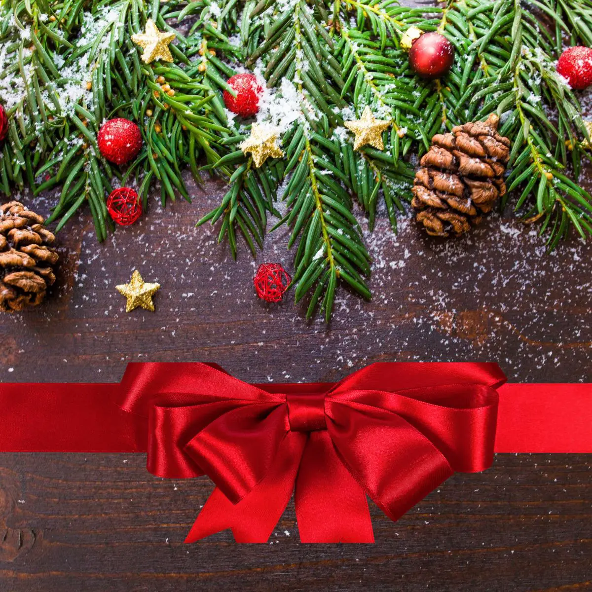 Ausmalbilder Weihnachten kostenlos drucken. Mit Tannenzweigen und Tannenzapfen dekorierte Holzplatte. Eine rote Schleife liegt ebenfalls auf der dunkelbraunen Holzplatte.